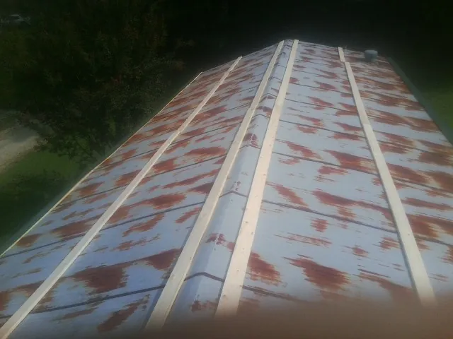 Rusted metal roof panels with new wood purlins before replacement — Storm Damage Roof Repair in Mazon by Roofing Brothers