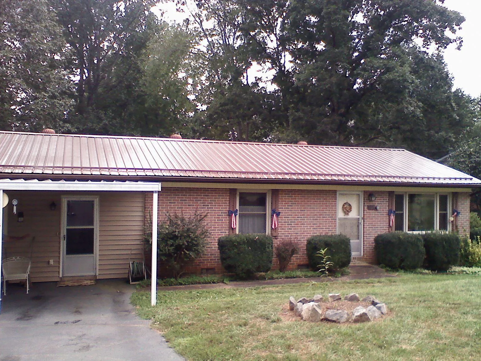 Bronze metal roof and carport on a brick ranch home — Roof Repair work by our crew in Mazon